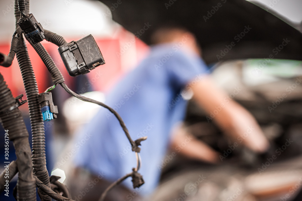 Car mechanic repairer service technician checks and repairs auto engine