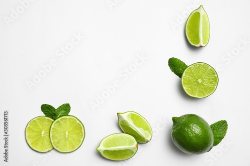 Flat lay composition with fresh juicy limes and mint on white background