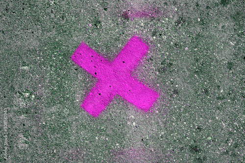 Magenta stencil cross on concrete wall. Urban