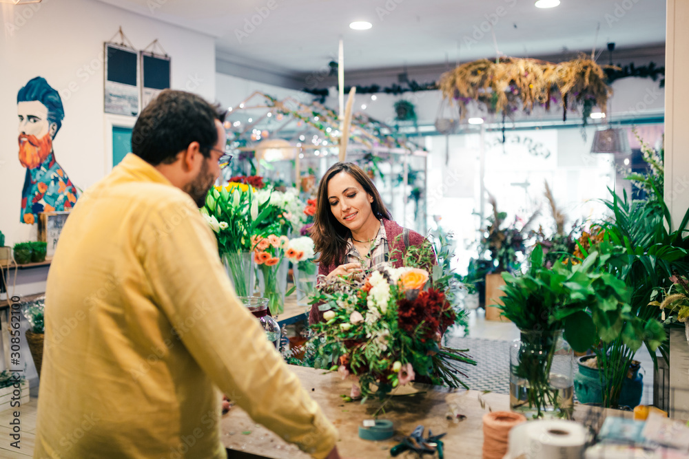 Young woman buying a bouquet of flowers in a florist Young woman buying a bouquet of flowers in a florist