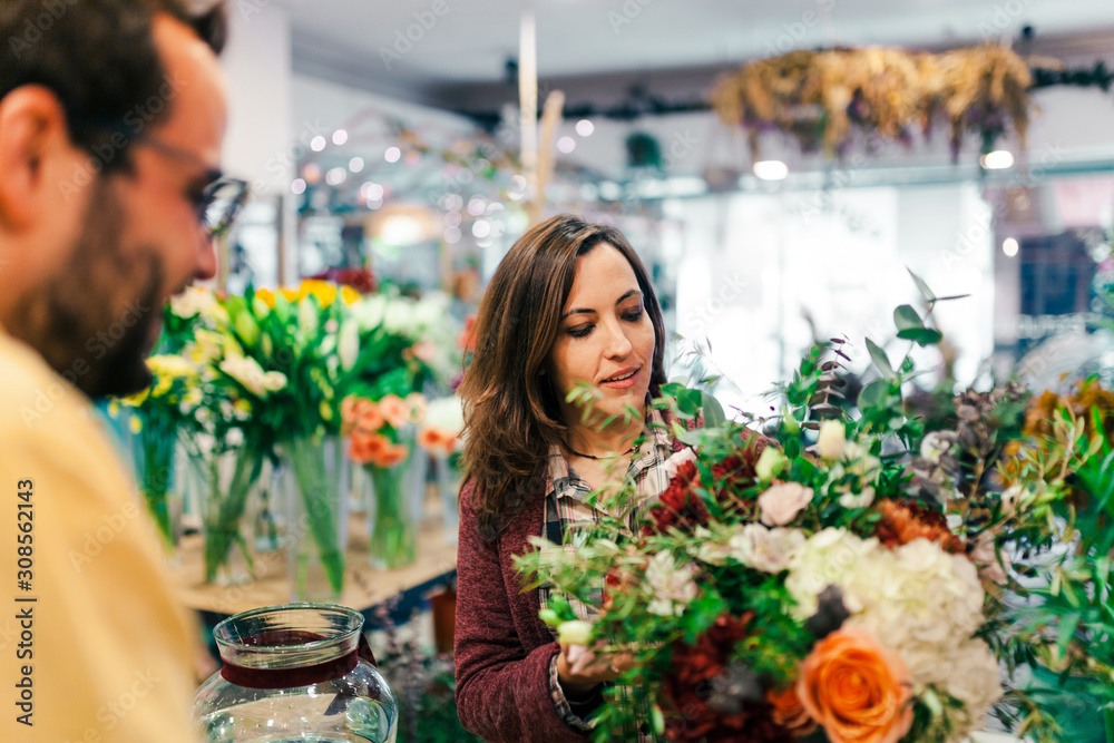 Young woman buying a bouquet of flowers in a florist