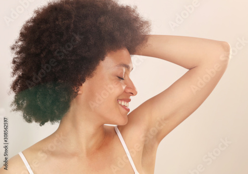 Armpit epilation, laser hair removal. YWoman holding arms up and showing underarms, smooth clean skin. photo