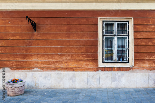 Classic old fashioned antique house facade with concrete wall and rustic window on a historic street