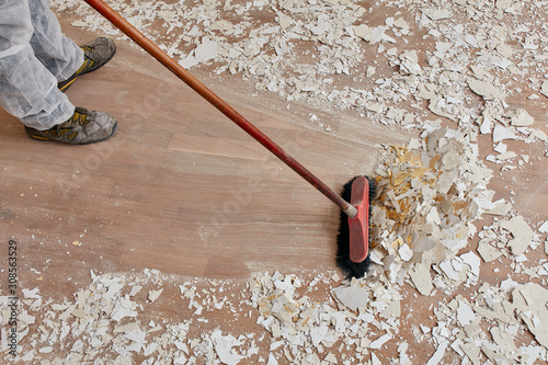 Builder sweeping the floor after renovation