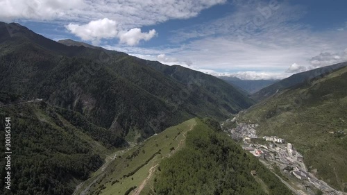 Drone flight towards a small Tibetan village (Siguniangshanzhen) in the valley. Filmed on the trekking route to Haizi Valley. photo