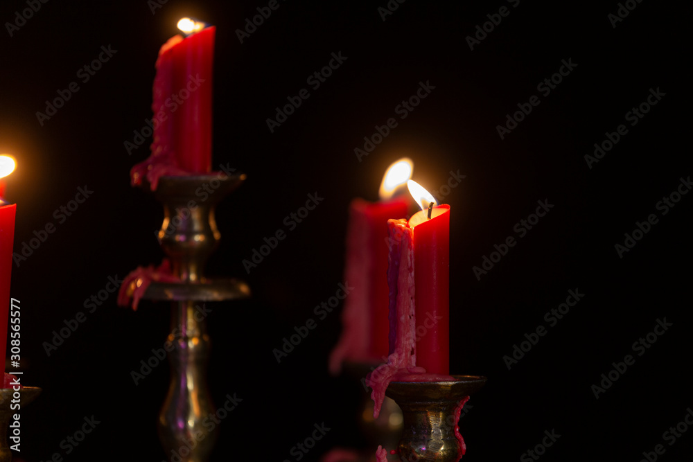 Bronze candle holders with red candles, with spilled resin. Bronze candle holders with red candles, with spilled resin.