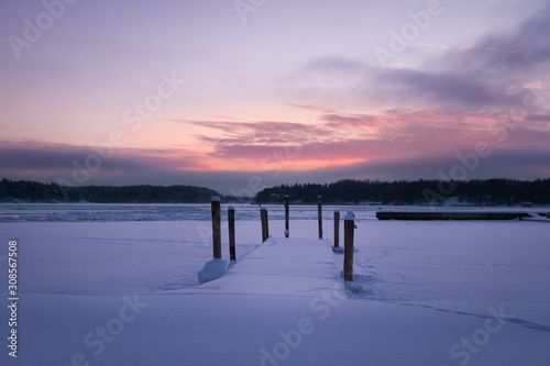 Snow covered pier at sunset. Turku  Finland.