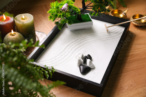 Beautiful miniature zen garden and candles on table