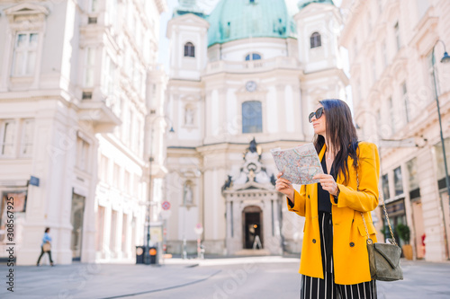 Young woman with a city map in city. Travel tourist girl with map in Vienna outdoors during holidays in Europe.