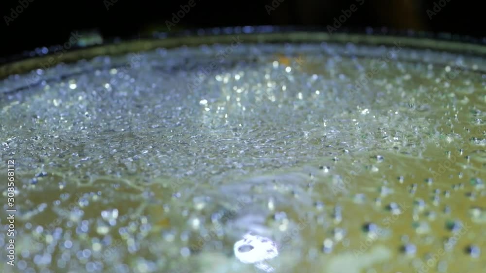 Drops water jumping on the drum on black background. Close up of drums perfused with water for special effect. Shot from slight low angle looking up Drops water jumping on the drum on black background. Close up of drums perfused with water for special effect. Shot from slight low angle looking up
