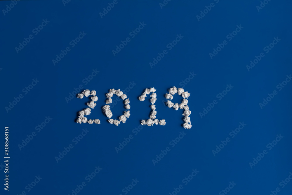 Bolitas de papel que escriben 2019 sobre mesa azul clásico las metas del año hechas bolas de papel