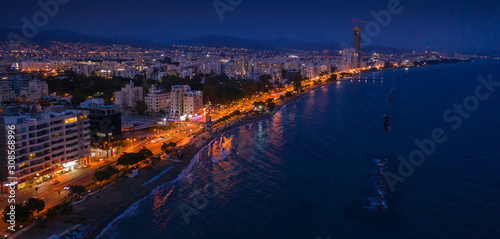 Aerial view of Limassol promenade or embankment with alley and buildings in Cyprus at night. Drone photo of mediterranean sea resort Limassol from above.