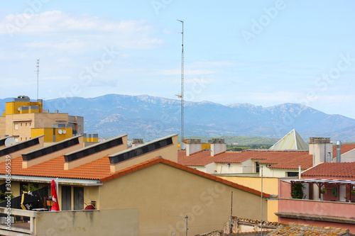 Tile roofs of houses on a background of snow-covered mountains, Europe, Spain.