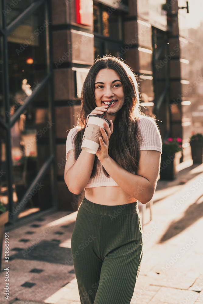 Beautiful smiling woman posing for the camera with coffee in the city. Beautiful smiling woman posing for the camera with coffee in the city.