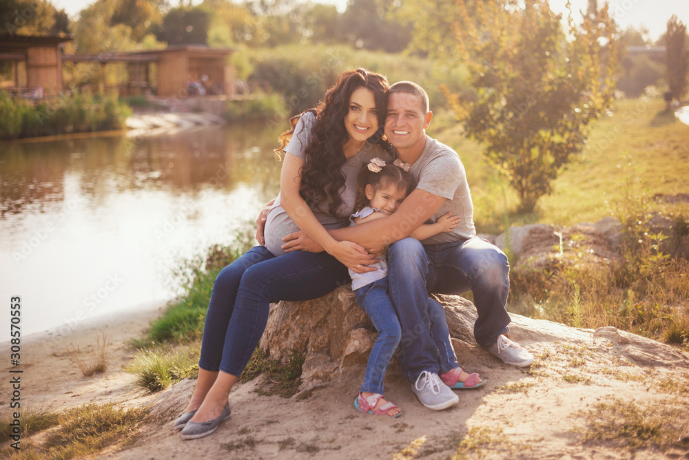 Happy pregnant family with little girl having fun in summer nature Happy pregnant family with little girl having fun in summer nature