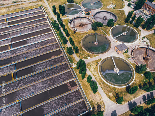 Modern wastewater treatment plant with round ponds for recycle dirty sewage water, aerial view from drone.