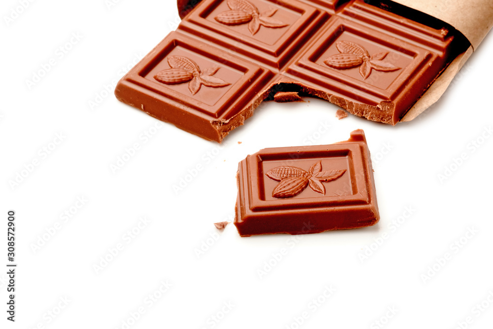 Broken chocolate bar on white table. Horizontal composition. Top view Broken chocolate bar on white table. Horizontal composition. Top view