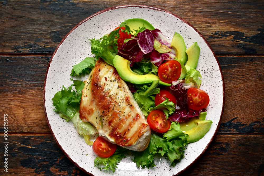 Grilled chicken breast with vegetable salad. Top view with copy space. Grilled chicken breast with vegetable salad. Top view with copy space.