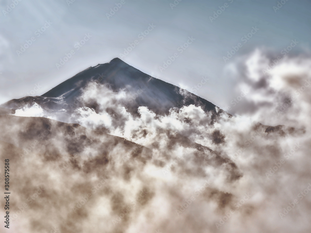 Mystical atmosphere by rising fog spirit at the foot of the volcano El Teide Mystical atmosphere by rising fog spirit at the foot of the volcano El Teide