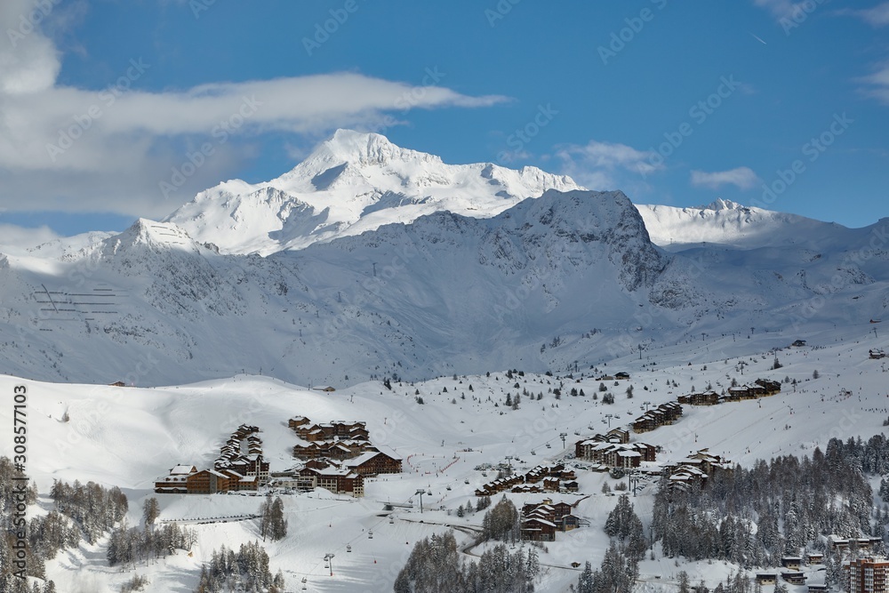 Winter snowy landscape with high mountains, ski slopes of Paradiski France, La Plagne village