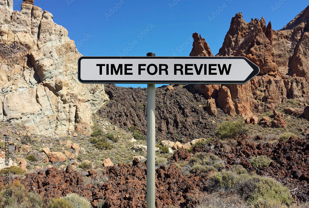 Road sign with TIME FOR REVIEW text under lava background
