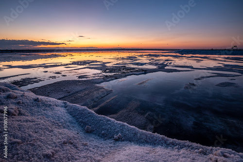 Nature reserve Saline Margherita di Savoia, Apulia, Italy: The salt pan. Salt flats area for sea salt production. A salt marsh, an ecosystem on Adriatic sea. Heaps of salt at sunset ready for harvest