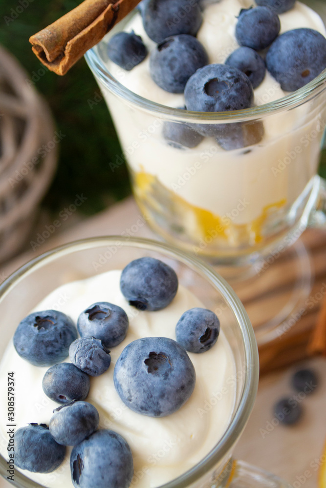 Glasses with blueberry and orange parfait with whipped sour cream. Christmas table, vertical image Glasses with blueberry and orange parfait with whipped sour cream. Christmas table, vertical image