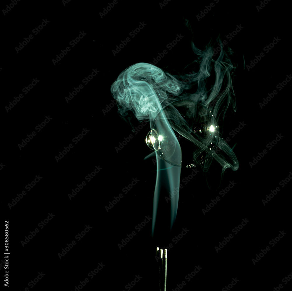 Green smoke trails with a large bubble in it on a black background