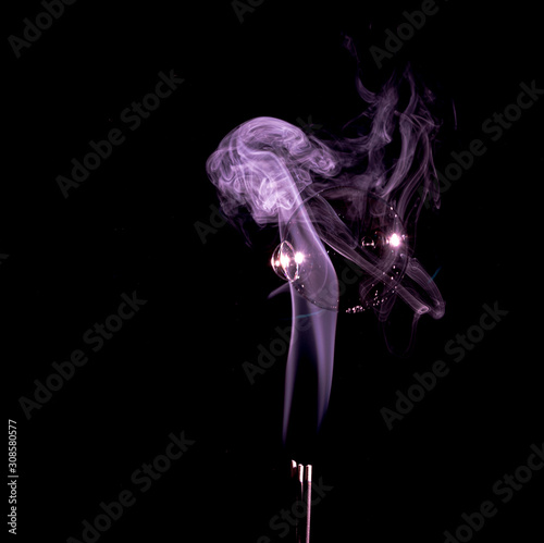 Purple smoke trail with bubbles in it on a black background