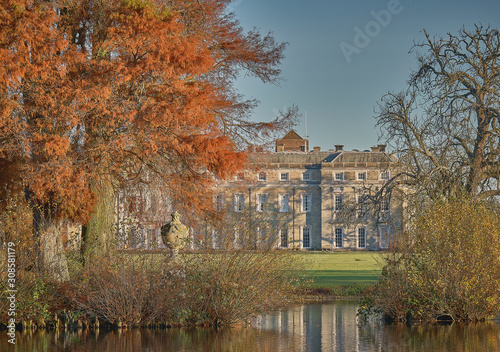 Petworth House and lake with golden autumn trees
