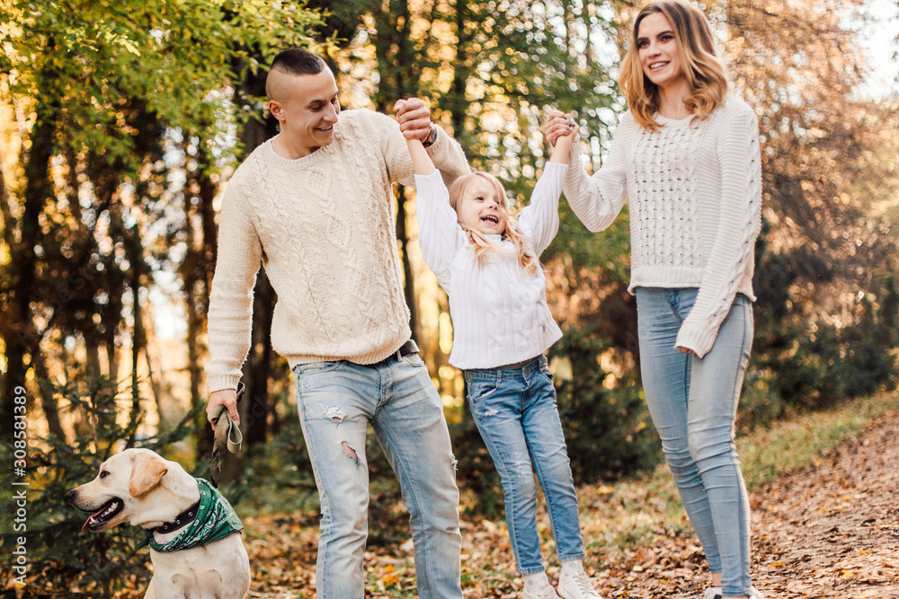 Happy beautiful family with dog labrador is having fun together walking the in park. Happy beautiful family with dog labrador is having fun together walking the in park.
