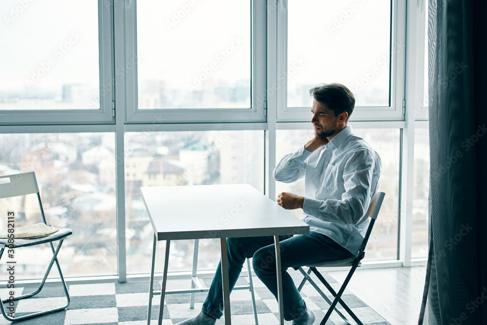 man sitting on chair in front of window man sitting on chair in front of window