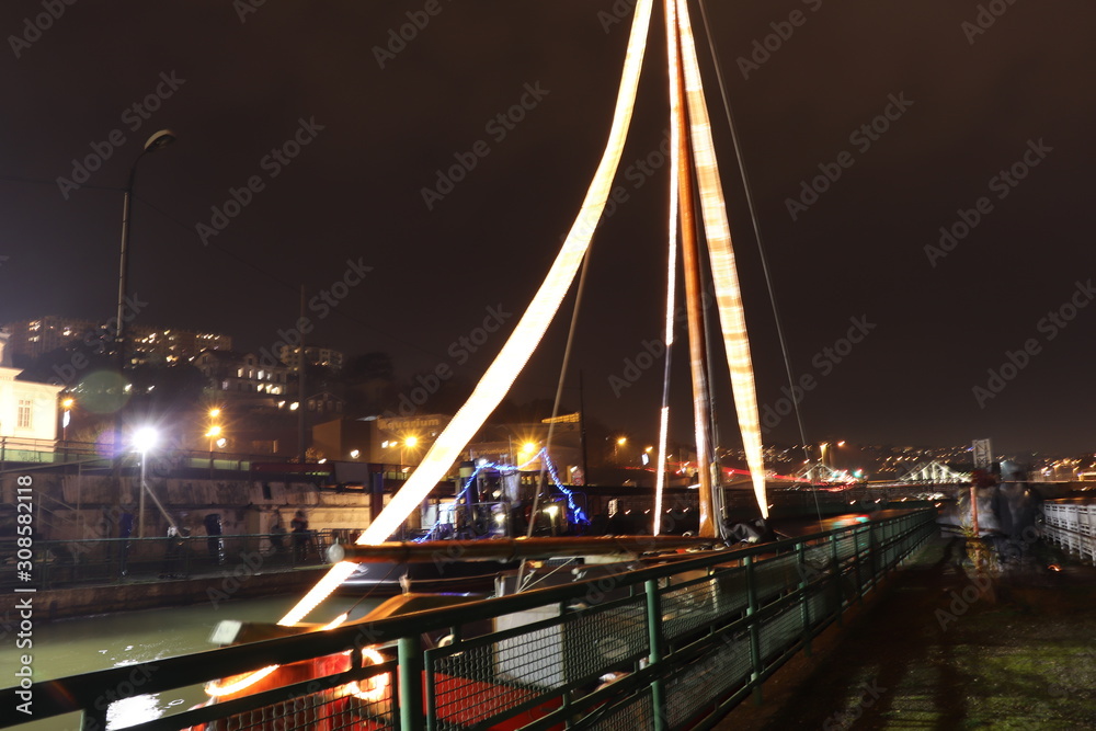 Obraz premium Bâteau illuminé la nuit sur le fleuve Rhône dans l'ancienne écluse de La Mulatière au sud de Lyon - Département du Rhône - Région Rhône Alpes - France