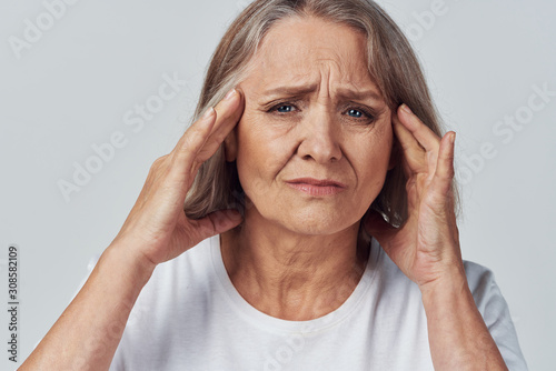 senior woman with headache isolated on white