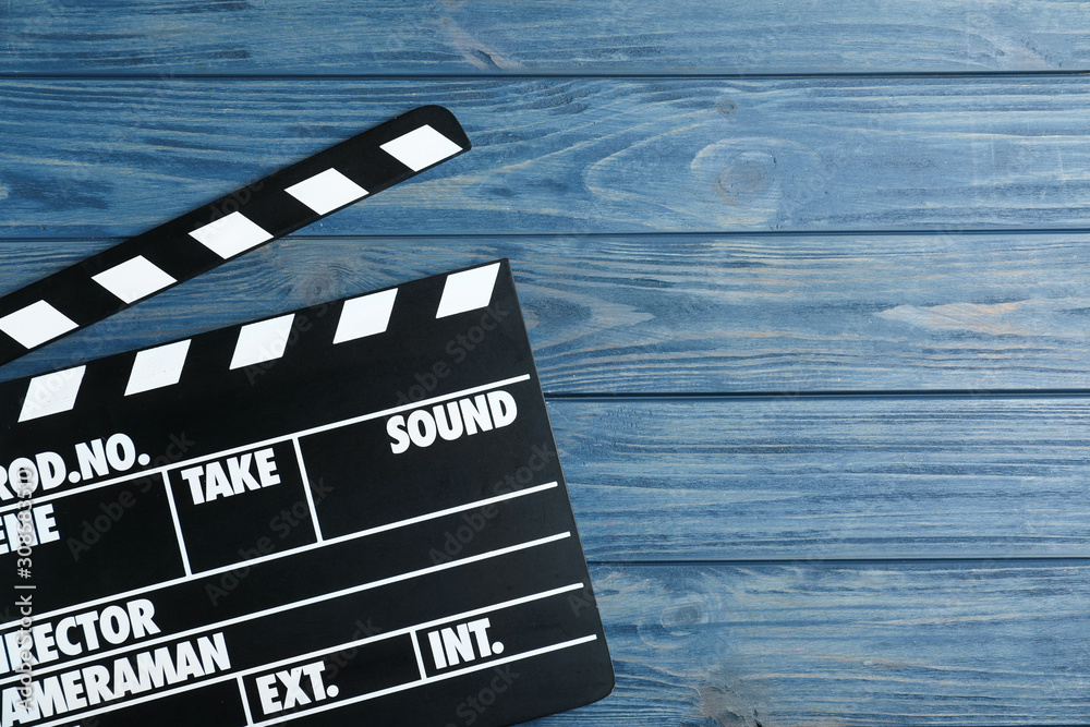 Clapper board on blue wooden background, top view with space for text. Cinema production
