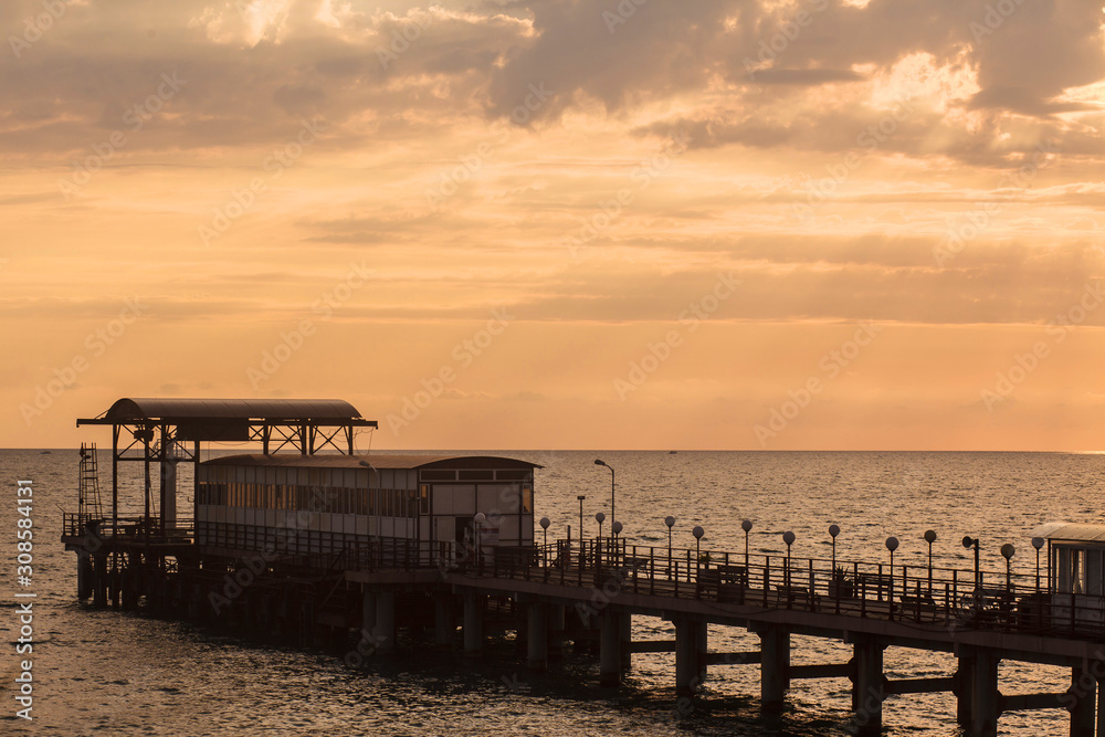 Sea pier at sunset on a warm autumn day. Vintage photo. The concept of tourism and leisure. Tourism day. Copy space
