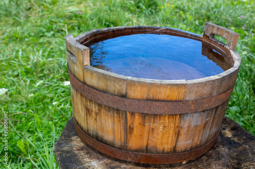 wooden vintage bucket or barrel of blue clean water © Nataliia