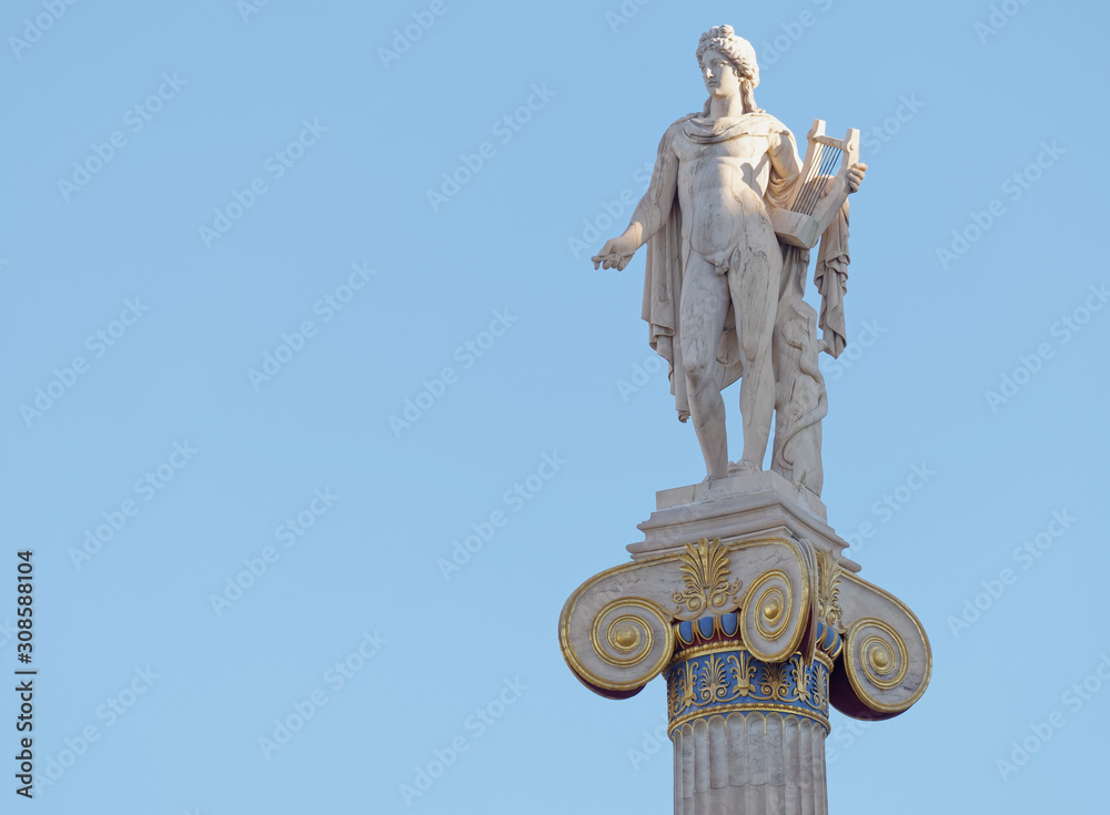Apollo statue with his face illuminated by sun rays on blue sky background, space for text Apollo statue with his face illuminated by sun rays on blue sky background, space for text