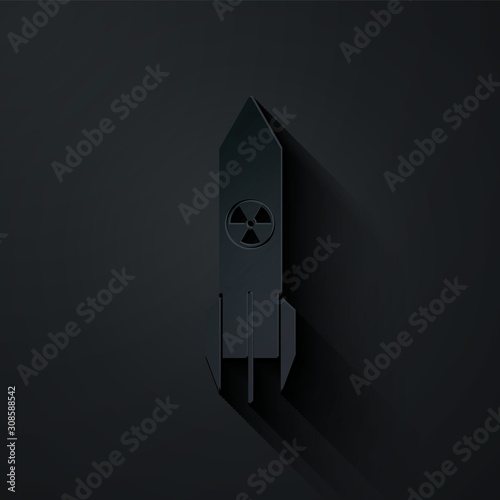 Paper cut Nuclear rocket icon isolated on black background. Rocket bomb flies down. Paper art style. Vector Illustration