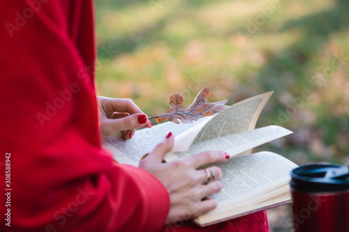 Female hands flipping paper book pages outdoors