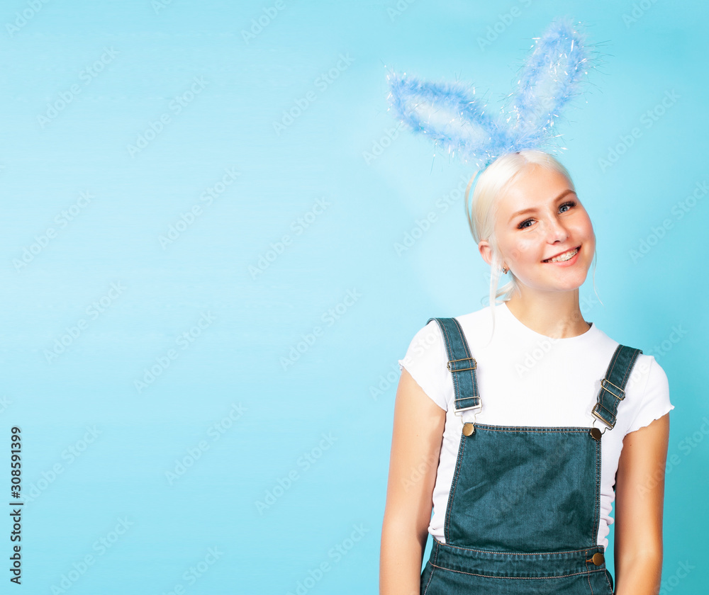 young pretty blond girl with rabbit ears posing cheerful on blue background, lifestyle people concept young pretty blond girl with rabbit ears posing cheerful on blue background, lifestyle people concept