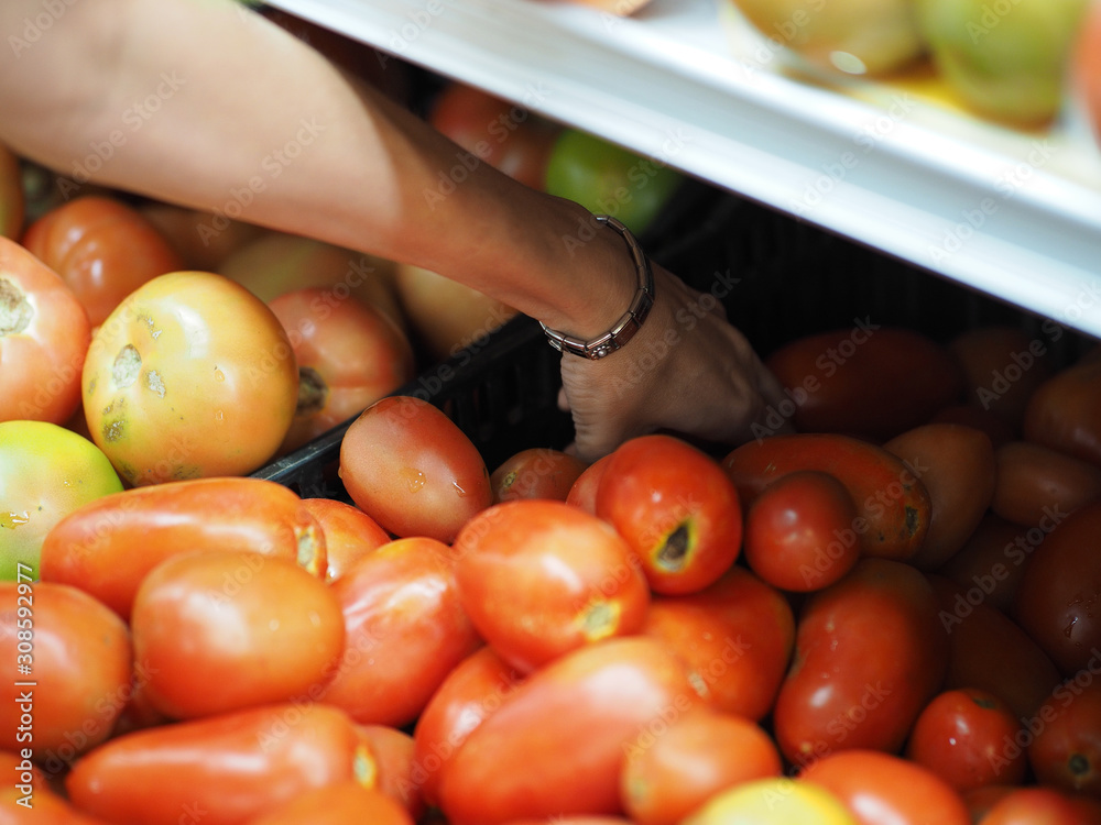 Girl picks tomatoes at the grocery store. Soft focus.