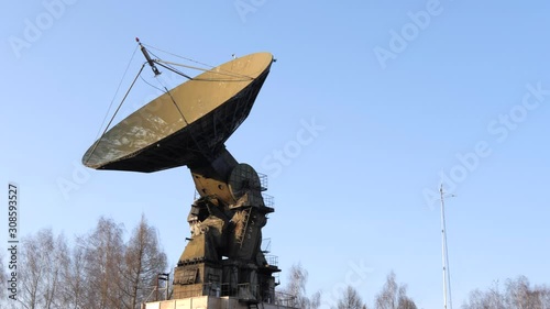 A large old radar at an old base in the middle of the forest. photo