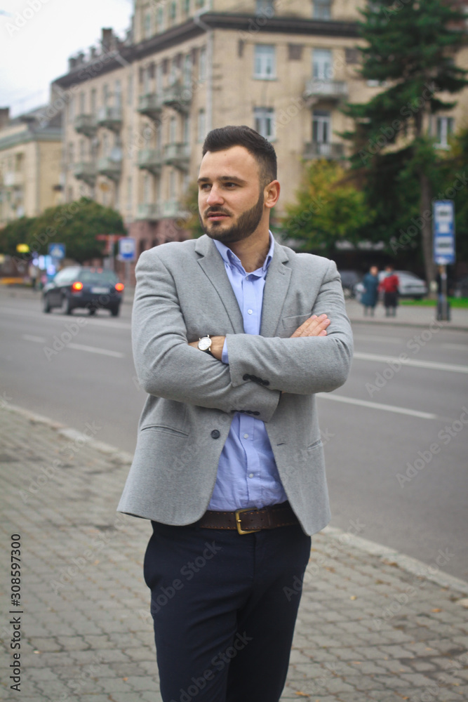 Portrait of a businessman on the street near the road of a European city. A bearded handsome man dressed stylishly. Fashionable guy hipster. Stock photos Portrait of a businessman on the street near the road of a European city. A bearded handsome man dressed stylishly. Fashionable guy hipster. Stock photos