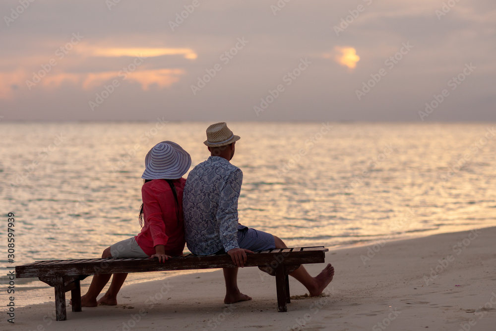 Beautiful wedding photoshoot of a couple. Beautiful bride in white wedding dress and groom having fun on shore sea. Tropical sea in the background. Summer vacation concept. Sunset on the ocean