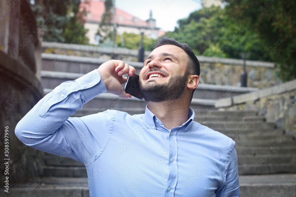Portrait of a bearded man near the big steps of an old European castle. Businessman talking on the phone. Fashionable guy with stylish clothes. Portrait of a bearded man near the big steps of an old European castle. Businessman talking on the phone. Fashionable guy with stylish clothes.