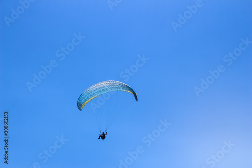 a paraglider flying in blue sky landscape in Indonesia