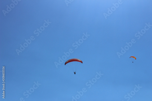 a paraglider flying in blue sky landscape in Indonesia