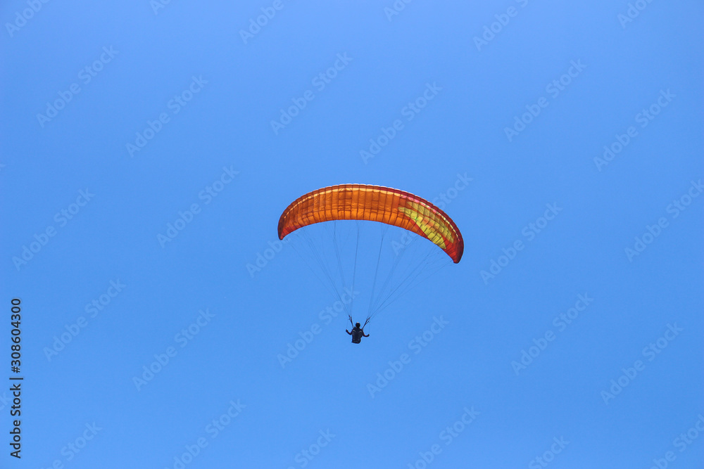 a paraglider flying in blue sky landscape in Indonesia a paraglider flying in blue sky landscape in Indonesia