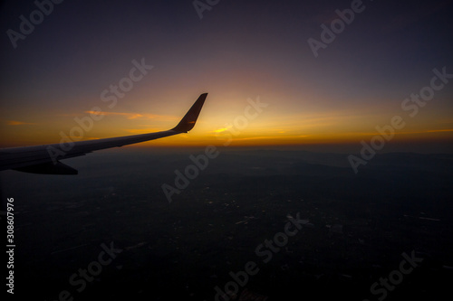 Blurred nature background from the plane window, can see the high angle nature (mountains, moist forest, morning sky) the beauty of nature during air travel